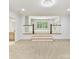 Bonus room features a split level and a view to an additional room with windows and shelving at 825 Hudson Pl, Davidson, NC 28036