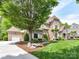 Beautifully landscaped home featuring a lush green lawn and mature trees for added curb appeal at 825 Hudson Pl, Davidson, NC 28036