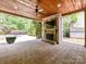 Inviting outdoor patio has a brick fireplace, ceiling fan, and a view of the lush backyard at 825 Hudson Pl, Davidson, NC 28036