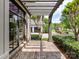 Covered brick patio featuring an open pergola, black frame windows, and lush greenery at 825 Hudson Pl, Davidson, NC 28036