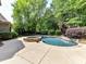 Beautifully designed backyard pool with spa, surrounded by lush greenery and mature landscaping for privacy at 825 Hudson Pl, Davidson, NC 28036