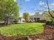 Large backyard features lush grass, manicured landscaping, mature trees, and a detached two-car garage at 894 Stratford Run Dr, Fort Mill, SC 29708