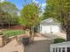 Backyard with a detached two-car garage, lush lawn, and paved patio seating area at 894 Stratford Run Dr, Fort Mill, SC 29708