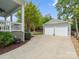 Spacious driveway with a detached two-car garage and patio is seen from the porch at 894 Stratford Run Dr, Fort Mill, SC 29708