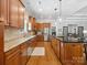 The open kitchen features custom wood cabinets, stainless steel appliances, and an island with bar seating at 894 Stratford Run Dr, Fort Mill, SC 29708