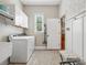 Bright laundry room featuring a washer, dryer, storage cabinets, and stylish board and batten at 894 Stratford Run Dr, Fort Mill, SC 29708