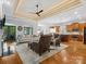 Open-concept living space with hardwood floors, a coffered ceiling, and seamless transition to the kitchen at 894 Stratford Run Dr, Fort Mill, SC 29708