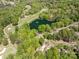 Aerial view of a neighborhood with homes nestled among lush greenery and adjacent to a lake at 9012 Saint Thomas Ln, Charlotte, NC 28277