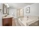 Bathroom showcasing a double vanity, large soaking tub, and separate shower with glass door at 9012 Saint Thomas Ln, Charlotte, NC 28277