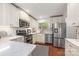 Modern kitchen featuring stainless steel appliances, white cabinets and countertops, hardwood floors, and natural lighting at 9012 Saint Thomas Ln, Charlotte, NC 28277