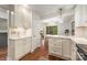Bright kitchen showcasing white cabinetry, stainless steel appliances, and an island with seating and hardwood floors at 9012 Saint Thomas Ln, Charlotte, NC 28277