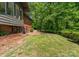 Brick home featuring a brick patio, mature trees and manicured lawn at 916 E Park Dr, Lincolnton, NC 28092