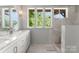 Bright bathroom with marble countertop vanity, decorative tile floor and walk in shower with window view at 916 E Park Dr, Lincolnton, NC 28092