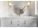 Contemporary bathroom featuring double vanity sinks, a round mirror, and stylish sconce lighting at 916 E Park Dr, Lincolnton, NC 28092