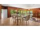 Bright dining room boasts wood paneling and large windows with a view of the wooded backyard at 916 E Park Dr, Lincolnton, NC 28092
