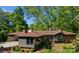 Expansive brick home featuring a covered parking area and plentiful trees at 916 E Park Dr, Lincolnton, NC 28092
