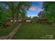 Inviting home with a stone pathway leading to the front door, surrounded by a well-manicured lawn and mature trees at 916 E Park Dr, Lincolnton, NC 28092