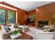 Spacious living room boasts wood paneling, fireplace with brick surround, and large windows with wooded views at 916 E Park Dr, Lincolnton, NC 28092