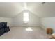Bright attic space with neutral carpet, white walls, and a window, offering potential for storage or additional living area at 1002 Christobal Ct, Indian Trail, NC 28079