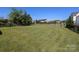 Large, grassy backyard surrounded by mature trees and fencing, offering ample space for recreation and privacy at 1002 Christobal Ct, Indian Trail, NC 28079