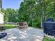 Outdoor patio with a grill, dining set, and peaceful tree-lined backyard at 1033 Lilly Pond Dr, Fort Mill, SC 29715