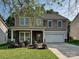 Charming two-story home featuring a stone-accented porch, a two-car garage, and a well-maintained lawn at 1033 Lilly Pond Dr, Fort Mill, SC 29715