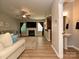 Open-concept living room features a fireplace, ceiling fan, wood floors, and flows into the kitchen and bathroom at 1033 Lilly Pond Dr, Fort Mill, SC 29715