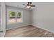 Bedroom featuring light gray walls, wood-look floors, a ceiling fan and a large window at 112 Cleveland Ave, Albemarle, NC 28001