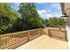 Freshly built wooden deck with open railing, overlooking a private backyard area and lush foliage at 112 Cleveland Ave, Albemarle, NC 28001