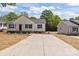 Traditional-style home with a spacious driveway, inviting curb appeal, and lush green trees at 112 Cleveland Ave, Albemarle, NC 28001
