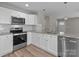 Well-lit kitchen featuring stainless steel appliances, granite counters, and white cabinets at 112 Cleveland Ave, Albemarle, NC 28001