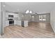 Spacious living room, featuring a kitchen with white cabinetry and wood-look floors at 112 Cleveland Ave, Albemarle, NC 28001