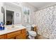 A well-lit bathroom with a wooden vanity, a framed mirror and decorative shower curtain at 1161 Constitution Park Blvd, Rock Hill, SC 29732