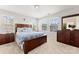A bright bedroom featuring a wooden bed, two side tables, and three large windows at 1161 Constitution Park Blvd, Rock Hill, SC 29732