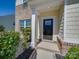 Inviting front entrance featuring a stylish black door, brick accents, and decorative shrubbery at 1210 Longwall Ln, Matthews, NC 28104