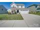 Charming two-story home with a well-manicured lawn, inviting curb appeal, and an attached two-car garage at 1210 Longwall Ln, Matthews, NC 28104