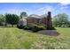 Back exterior featuring a wooden deck, brick chimney and a lush landscaped yard, creating a private outdoor retreat at 123 Shoreview Dr, Mooresville, NC 28117