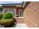 Close-up of a brick home's front entry with a charming wreath, steps, and manicured landscaping, offering curb appeal at 123 Shoreview Dr, Mooresville, NC 28117