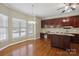 Bright kitchen featuring wood cabinets, a center island, hardwood floors, and a view of the backyard at 123 Shoreview Dr, Mooresville, NC 28117