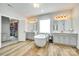 Bright bathroom with dual vanities, modern soaking tub, walk-in closet, and wood-look flooring at 1336 W Rebound Rd, Indian Land, SC 29720