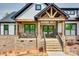 Inviting stone-clad front porch with wooden beams and a cozy seating area, leading to the entrance at 1336 W Rebound Rd, Indian Land, SC 29720