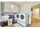 Laundry room featuring white cabinets, laundry sink, and modern washer and dryer units at 1336 W Rebound Rd, Indian Land, SC 29720