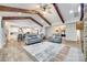 Open-concept living room with a vaulted ceiling, wood beams, and a seamless transition to kitchen and dining area at 1336 W Rebound Rd, Indian Land, SC 29720