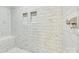 Close up of bright, tiled shower stall with built-in shelving and modern hardware at 1336 W Rebound Rd, Indian Land, SC 29720