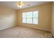 Neutral bedroom features a large window that fills the space with light at 13936 Mallard Lake Rd, Charlotte, NC 28262