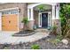 Charming front entry featuring stone accents, lovely landscaping, and a welcoming front door at 13936 Mallard Lake Rd, Charlotte, NC 28262