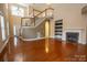 Open-concept living area features a fireplace, staircase, and hardwood floors at 13936 Mallard Lake Rd, Charlotte, NC 28262