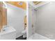 Stylish bathroom boasts tile shower and tub, sleek white vanity, and wood plank ceiling at 1430 Mollys Backbone Rd, Catawba, NC 28609