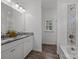 Bright bathroom featuring a double sink vanity with granite countertops and a shower-tub combo at 14532 E Rocky River Rd, Davidson, NC 28036