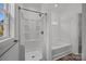 Bathroom featuring shower stall, tub, and a window for natural light at 14532 E Rocky River Rd, Davidson, NC 28036